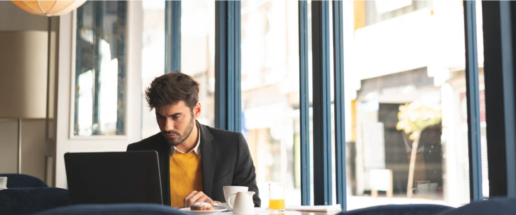 Professional working on a laptop by a window